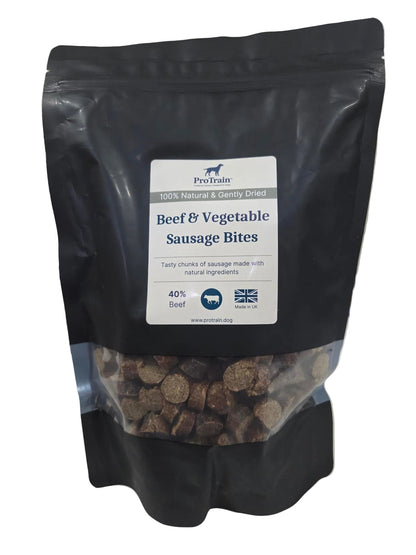 A black stand-up pouch of ProMax Beef & Vegetable Sausage Bites dog food, with a clear window showing the brown kibble inside, photographed on a light surface.